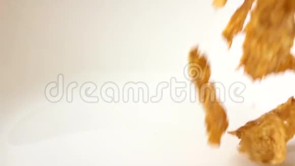 黄金玉米片散射在白色板块宏观超慢运动镜头视频的预览图