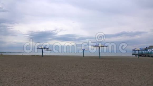 阴天有空沙滩和大太阳伞4K低季平底锅视频的预览图