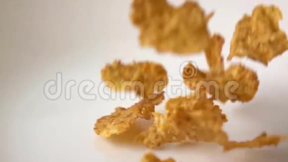 超级慢动作玉米片与水果和葡萄干落在盘子上视频的预览图