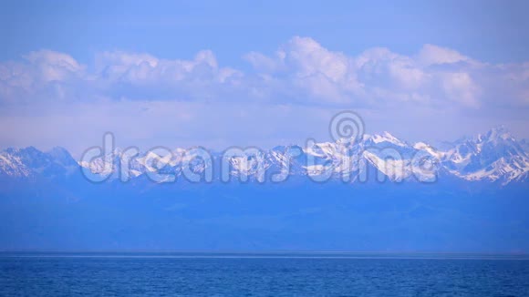 吉尔吉斯斯坦伊塞克库尔湖和白雪覆盖的山脉4K焦镜头拍摄视频的预览图