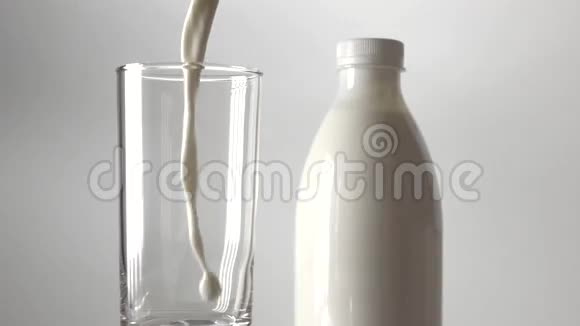 一瓶牛奶和牛奶倒入玻璃中超级慢动作视频视频的预览图