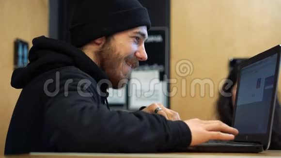 在咖啡馆用笔记本电脑工作的年轻人视频的预览图