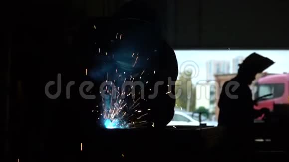 在金属行业工作的焊工焊工在建筑物的黑暗中工作这个人焊接铁器设计的细节视频的预览图