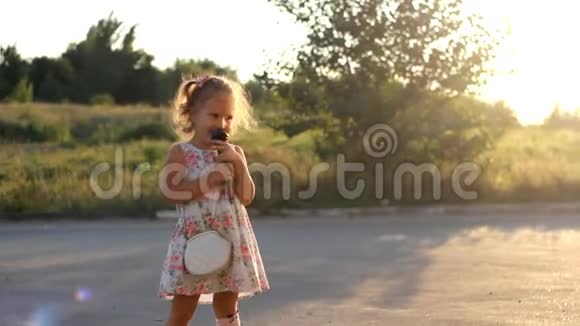 童女在夏日夕阳的余晖中对着麦克风唱着一首歌视频的预览图