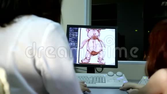 女青年医生检查毛绒熊体器官儿童玩具核磁共振成像断层扫描视频的预览图