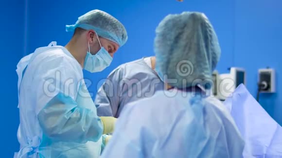 专业外科医生团队在蓝色手术室做手术视频的预览图