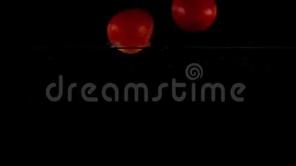 超级慢动作红西红柿在水中漂浮黑色背景视频的预览图