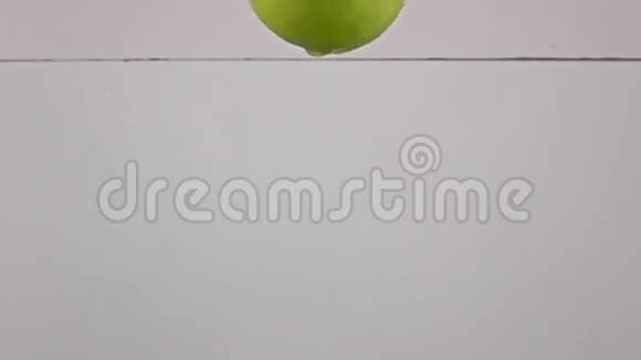绿苹果倒在水中接近灰色背景超级慢动作视频的预览图
