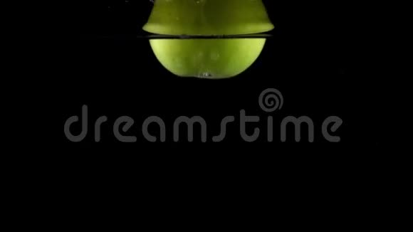 绿色苹果在黑色背景下在水中落下动作非常慢视频的预览图