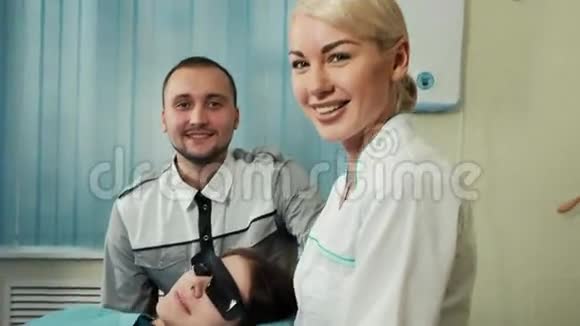 快乐的牙医和护士团队与病人在牙科办公室视频的预览图
