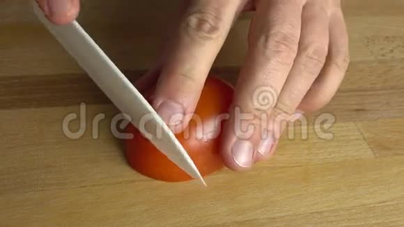 做蔬菜沙拉在砧板上切红番茄4K近距离射击视频的预览图