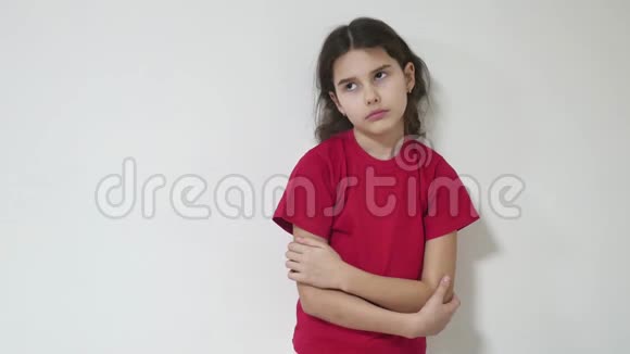 女孩孩子悲伤孤独沮丧站在墙附近拥抱自己在室内视频的预览图