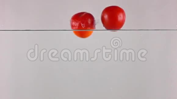 高速摄像视频红色成熟番茄溅水灰色背景视频的预览图