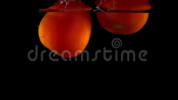 特写超级慢动作视频两个红色成熟的西红柿掉下来在水中漂浮视频的预览图