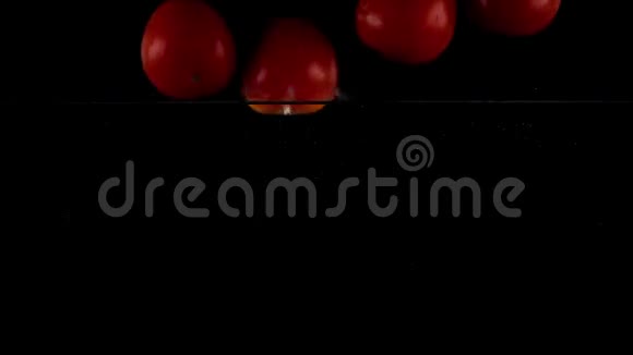 超级慢动作四个红番茄落在水里漂浮黑色背景视频的预览图