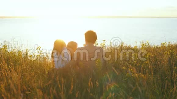 幸福的一家人在河边看日落视频的预览图