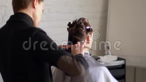 男美发师在美容院给女孩子做发型视频的预览图