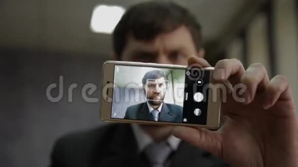 忙碌的办公室工作人员伸长脖子看着手机摄像头富尼商人用手指捏鼻子刮胡子视频的预览图