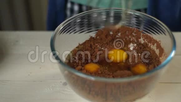 烹饪蛋糕男人用手缓慢地在玻璃碗里搅拌原料视频的预览图