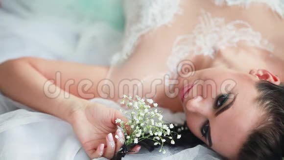 新娘穿着婚纱坐在椅子上那女孩正在为她的婚礼做准备视频的预览图