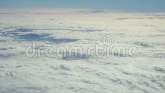 蓝天和白色的堆云穿过飞行飞机的舷窗视频的预览图