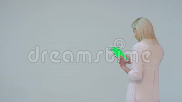 医生在白色背景下按下平板电脑的绿色屏幕视频的预览图