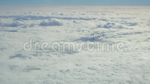 蓝天和白色的堆云穿过飞行飞机的舷窗视频的预览图