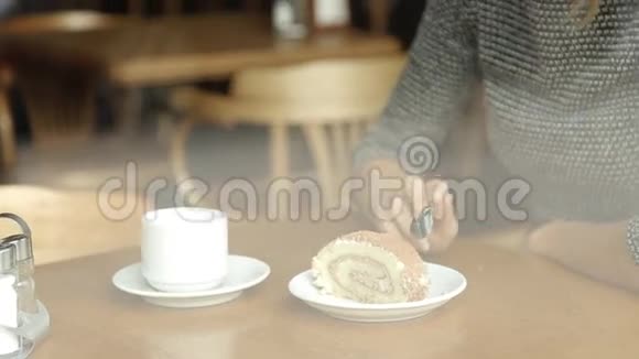 女人在咖啡馆里吃美味的蛋糕喝咖啡视频的预览图