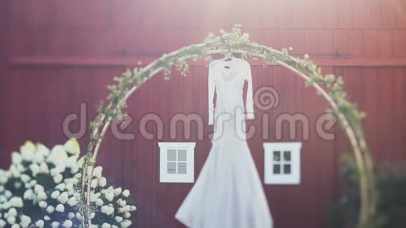 优雅的婚纱挂在拱门上在白天装饰着鲜花视频的预览图