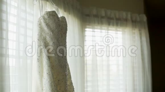 优雅的白色婚纱挂在窗户上视频的预览图