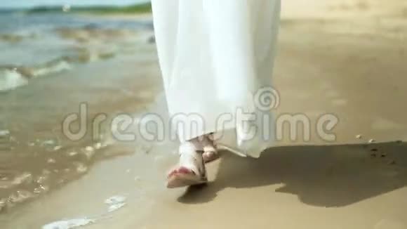 在阳光明媚的4k天气穿着白色连衣裙的女人在海滩上开着花视频的预览图