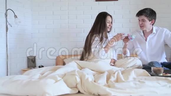 一对夫妇在阁楼房间的床上喝茶视频的预览图