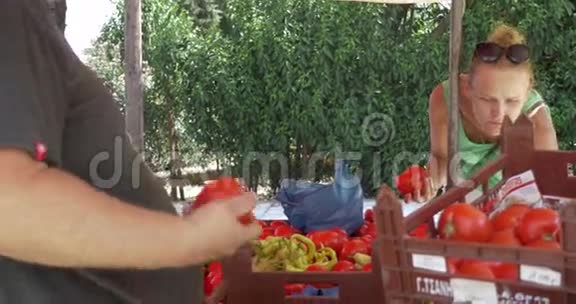 年轻女子在街头小贩摊买番茄视频的预览图