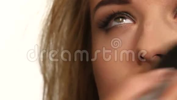 化妆师在女人身上涂上闪光粉视频的预览图