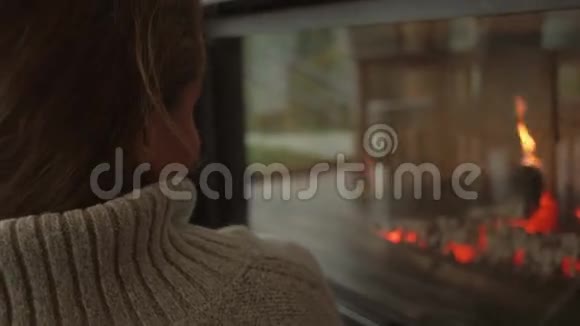 孤独的女人在靠近火的地方休息后景视频的预览图