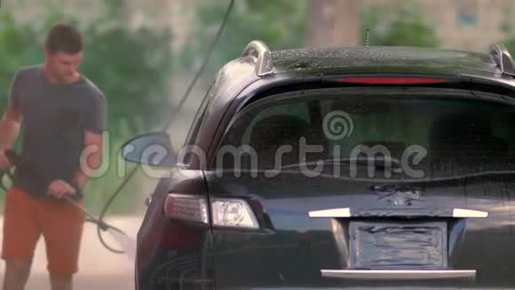 年轻人用高压泡沫清洗汽车视频的预览图