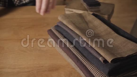 特写镜头从堆栈中选择羊毛年轻人做裁缝在车间里使用缝纫机视频的预览图