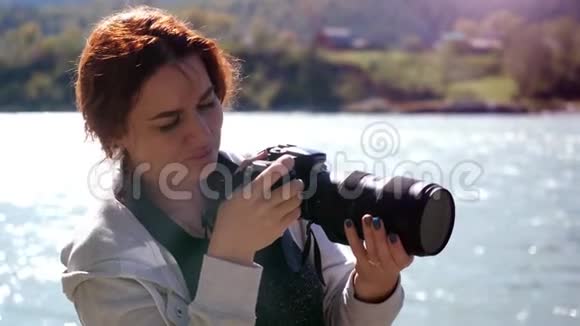 美丽的女人与红色头发摄影师拍照使用专业相机户外远足女性徒步旅行者视频的预览图
