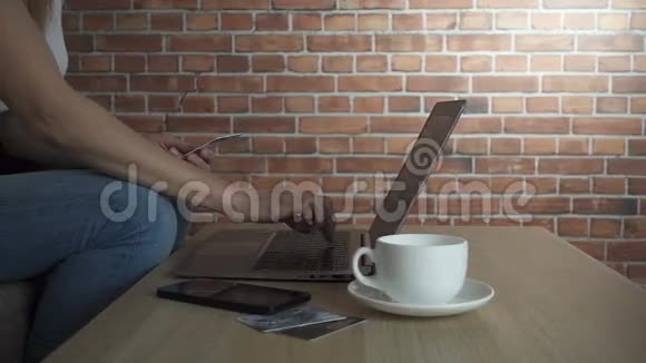 网上购物概念女人手拿信用卡用笔记本电脑慢动作高清视频视频的预览图
