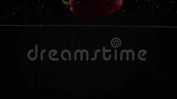 甜红辣椒在水里掉下来黑色背景超级慢镜头视频的预览图