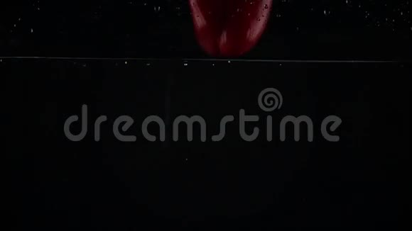 红铃椒在水里掉下来黑背景超级慢镜头视频的预览图