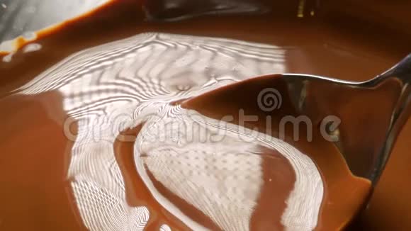 用勺子混合和倒入融化的巧克力大型慢动作视频视频的预览图