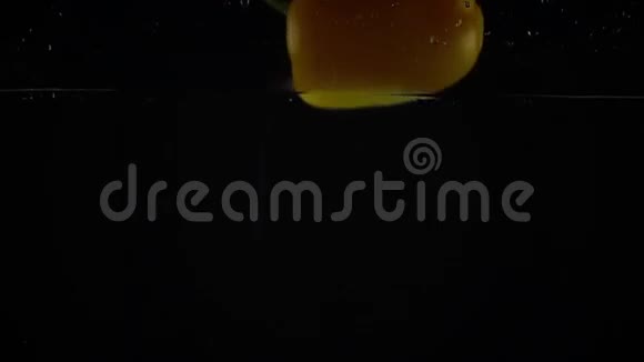 黄铃椒倒在水里黑背景超慢动作镜头视频的预览图