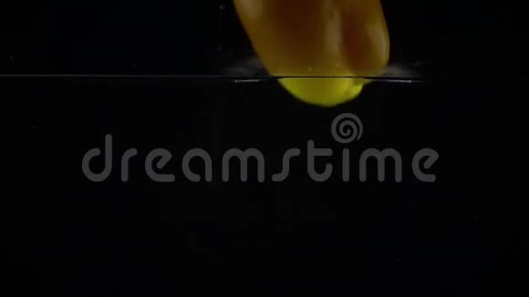 甜黄椒倒在水里黑色背景超级慢镜头视频的预览图