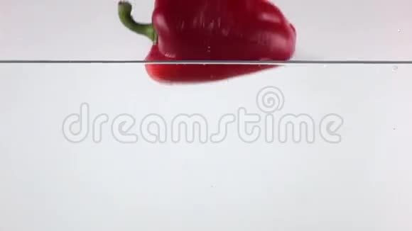 甜红辣椒在水里掉下来白色背景超级慢镜头视频的预览图