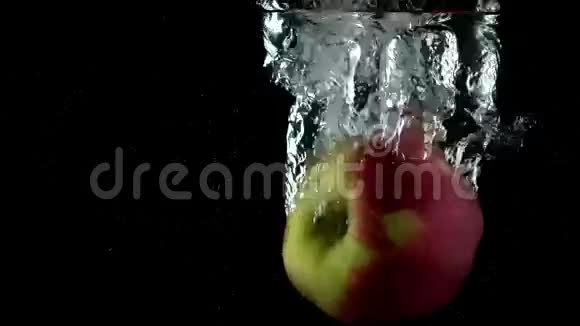 在黑色背景下苹果掉进水里超级慢动作视频的预览图