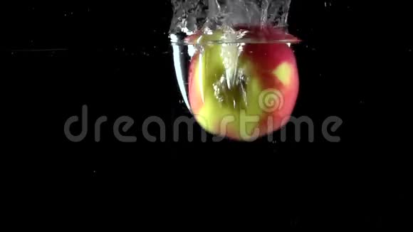 近距离拍摄苹果掉进水中的黑色背景超级慢动作视频的预览图