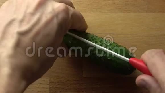 人把整根绿黄瓜劈在木切割板上4K关闭视频视频的预览图
