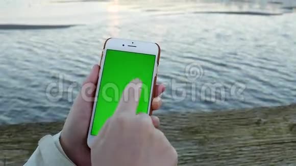女子手持绿屏显示手机视频的预览图