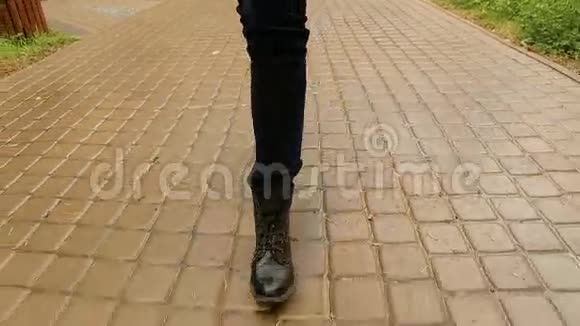 穿黑鞋和牛仔裤的女性脚在路上视频的预览图